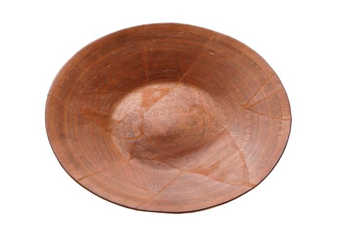 Plato con elementos simbólicos acuáticos y geométricos