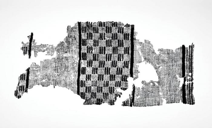Fragmento de textil de algodón cremado con diseños geométricos bordados