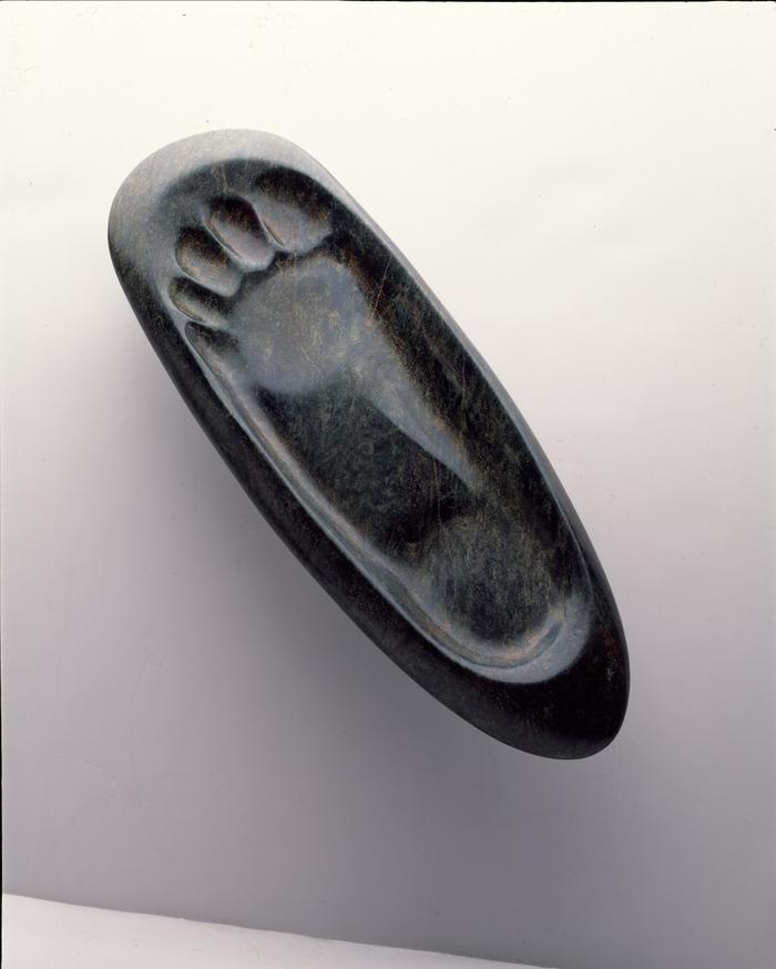Piedra verde con una huella en relieve